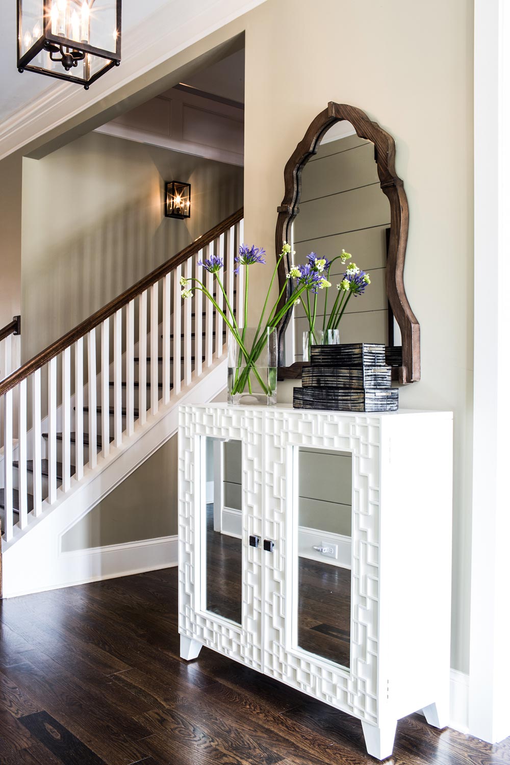 White entryway table with decorative mirror.