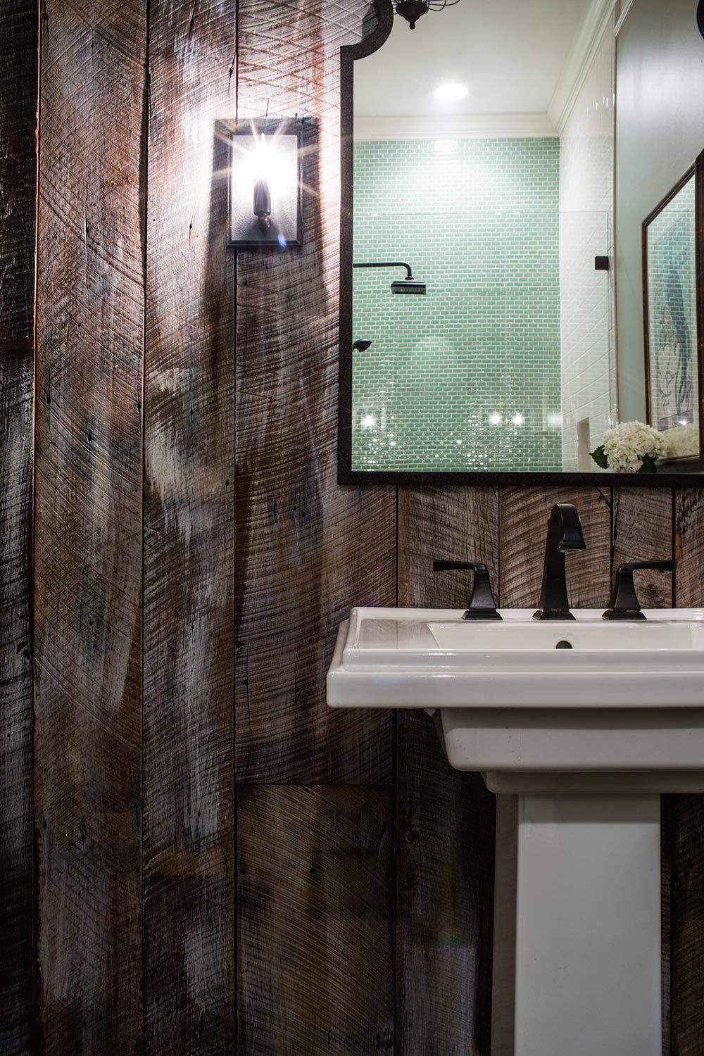 Wood bathroom walls. Green tile shower.