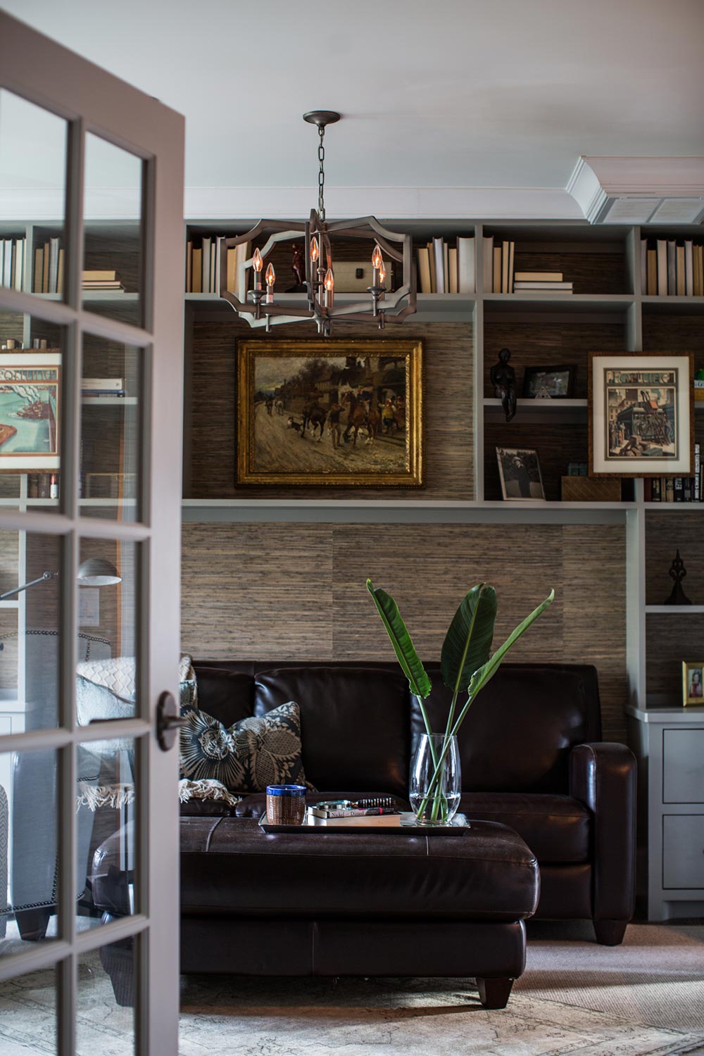 Moody library. Dark grass cloth wallpaper. Chic leather furniture. Library built-ins. 