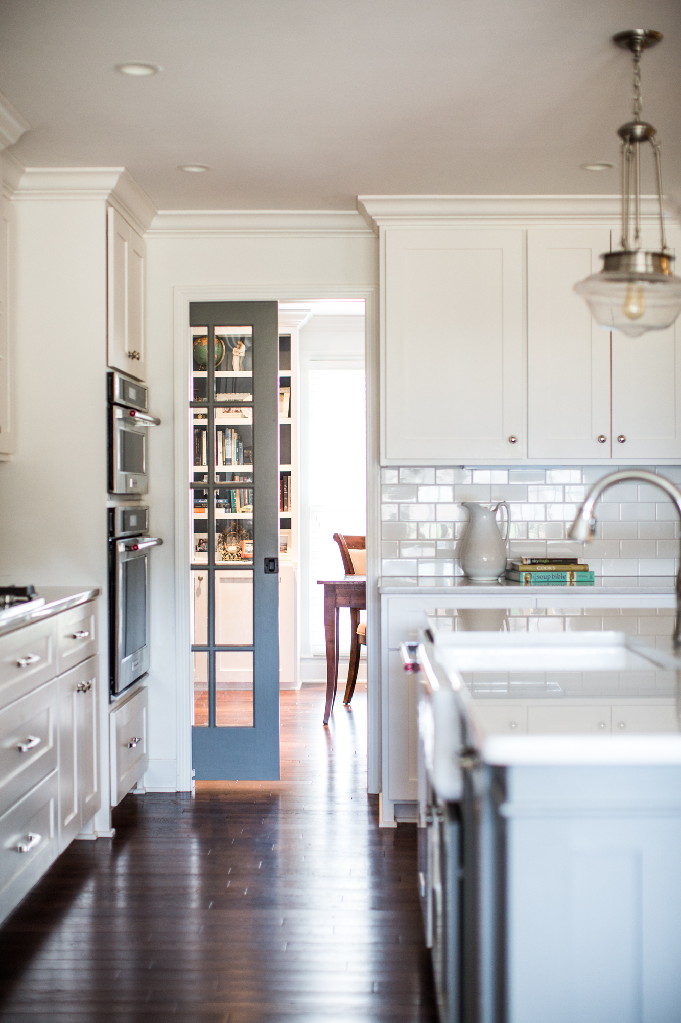 White kitchen. Subway tile backsplash. Dark wood flooring.