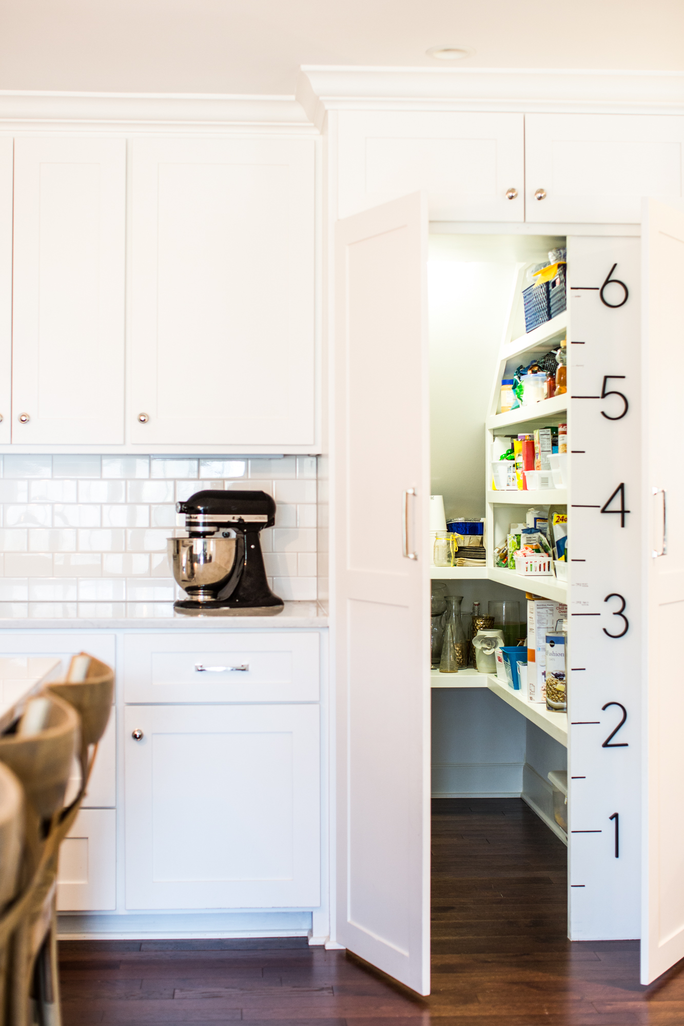 White kitchen. Subway tile backsplash. Large ruler