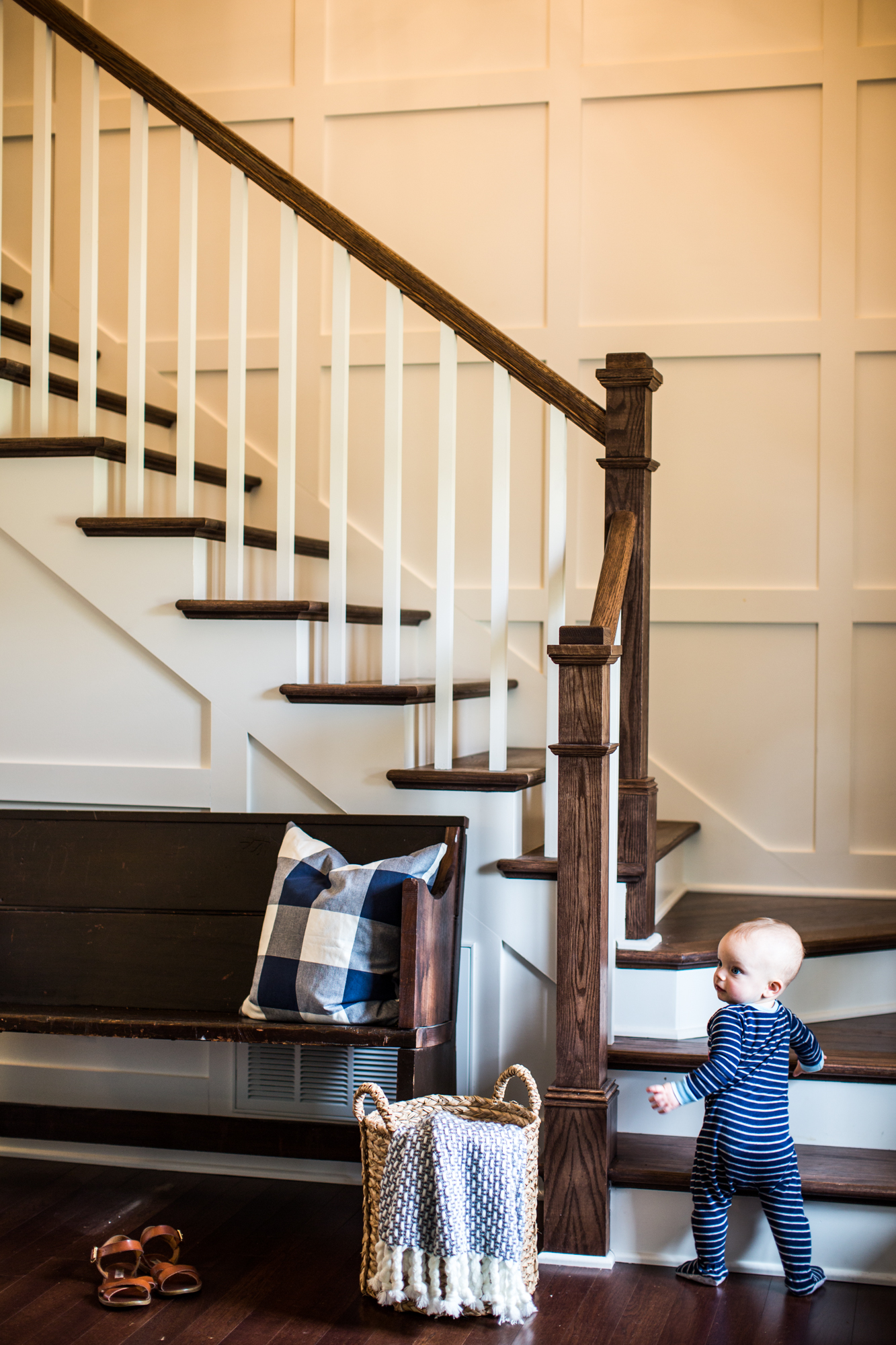 Natural wood staircase. White paneled walls.