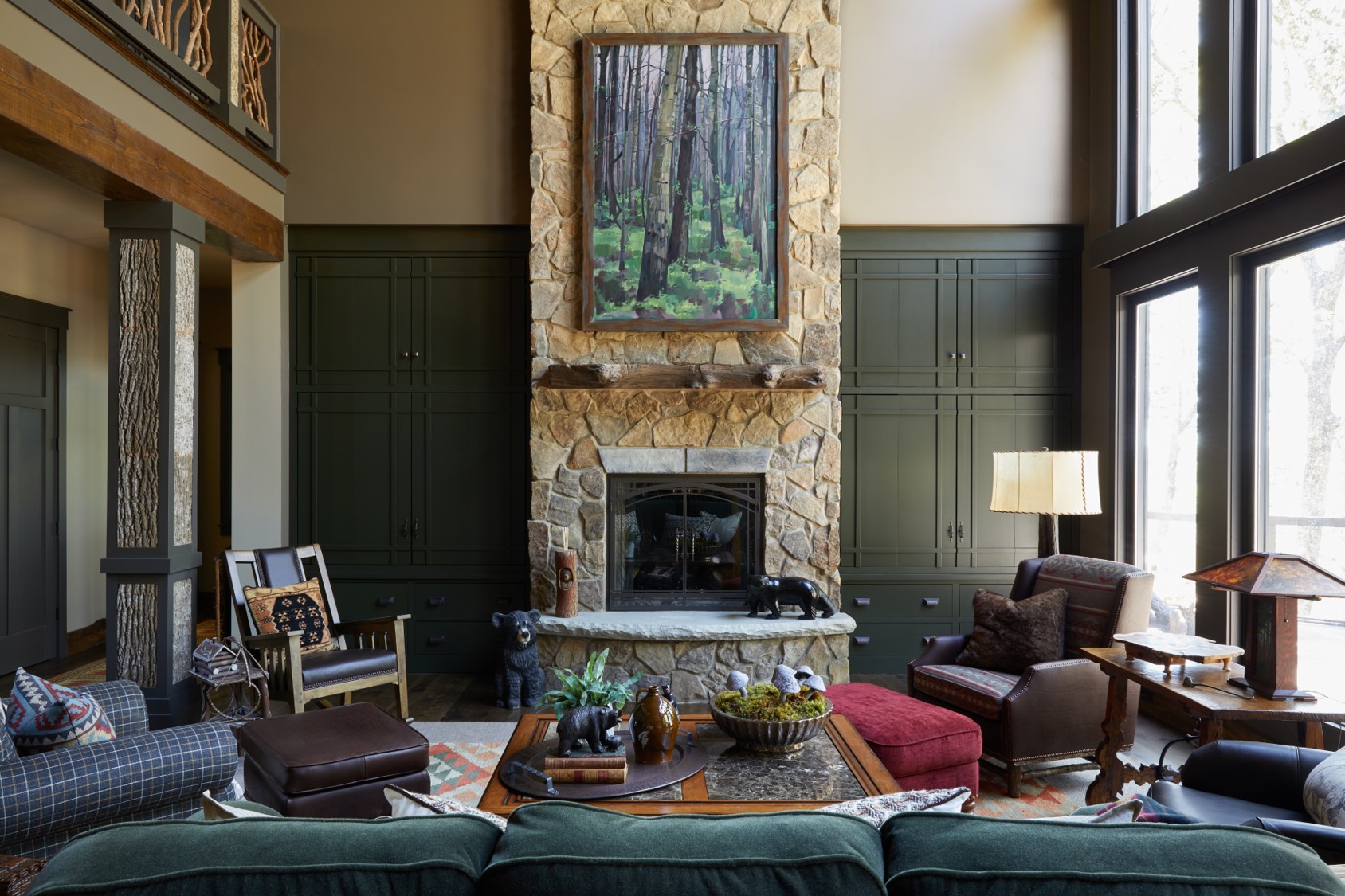 Dark green built-ins. Statement stone fireplace. Big windows with natural lighting